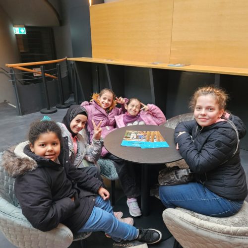 die Kinder sitzen an einem Tisch und lächeln